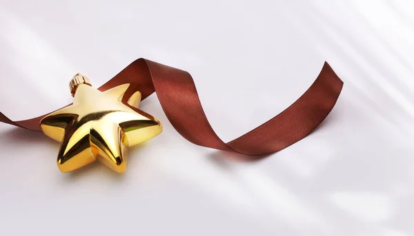 Close Boże Narodzenie Złoty Brokat Gwiazda Brązową Wstążką Beżowym Egzemplarzu — Zdjęcie stockowe
