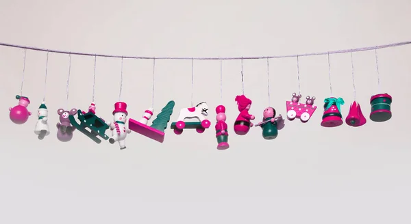 Małe Dekoracyjne Drewniane Zabawki Wiszą Girlandy Beżowej Szarej Ścianie — Zdjęcie stockowe