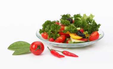 Tomato, cucumber, olives, parsley, pepper in salad on light background.