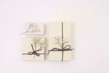 Craft gift boxes with flower wreath on light beige background. Copy space minimalism style template background. Flat lay, top view