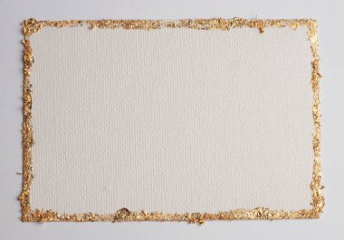 Bej rengi gri kağıdın arka planında altın (bronz) parıltılı boş tuval çerçeve. Soyut kopyalama alanı dokusu.
