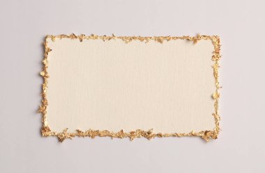 Bej rengi gri kağıdın arka planında altın (bronz) parıltılı boş tuval çerçeve. Soyut kopyalama alanı dokusu.