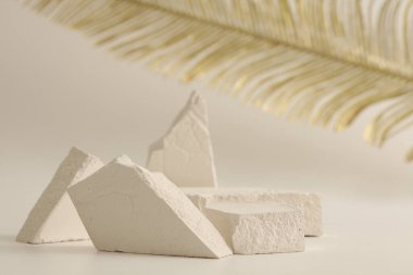 Doku taşı eko podyum ve açık bej arka planda altın yaprak. En az canlı ürün sunum sahnesi.