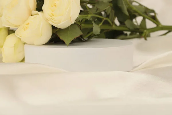 Bukiet Żółty Kwiat Róży Białym Podium Jedwabiu Tkaniny Jasnobeżowe Tło — Zdjęcie stockowe