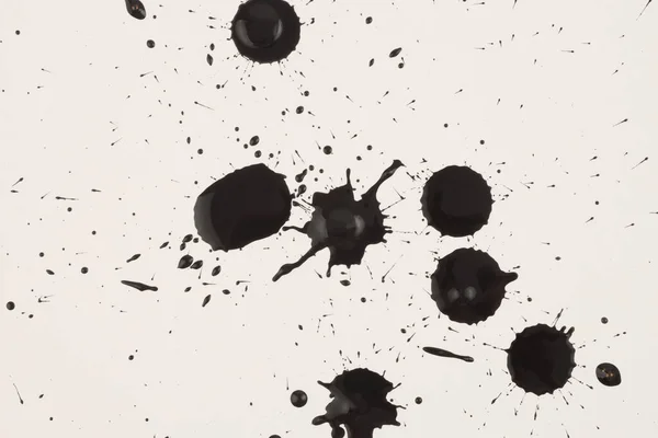 黒インクと水彩ドロップスプラッシュブロットライトベージュ紙の背景 — ストック写真