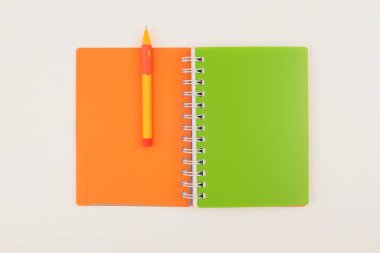 Neon rengi boş kağıdı kopyala ve bej renkli nötr masaya kalem koy. Sanat merkezi ofis masası çalışma alanı. Düz yatıyordu, üst.