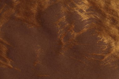 Sanatsal el, yağlı boya ve akrilik lekeli tuvali boyadı. Soyut doku altın, bronz parıltı ve kahverengi renk lekesi fırça darbesi dokusu arka planı.