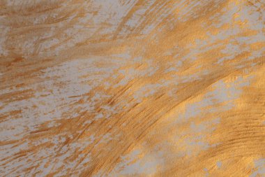 Sanatsal el, yağlı boya ve akrilik lekeli tuvali boyadı. Soyut doku altın, bronz parıltı ve bej rengi fırça darbesi dokusu arka planı.