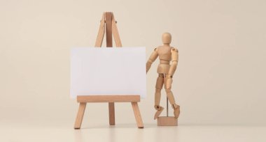 Küçük ahşap sehpanın üzerine boş kopya kâğıt tuval. Art Light bej arkaplan.