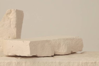 Bej ışıklı fotokopi arka planında beyaz taşlar platformu. En az boş ürün sunum sahnesi.