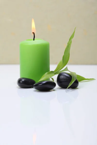 Płonąca Zielona Świeca Czarne Kamienie Liść Bambusa — Zdjęcie stockowe