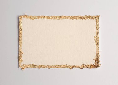 Bej rengi gri kağıdın arka planında altın (bronz) parıltılı boş tuval çerçeve. Soyut kopyalama alanı dokusu.