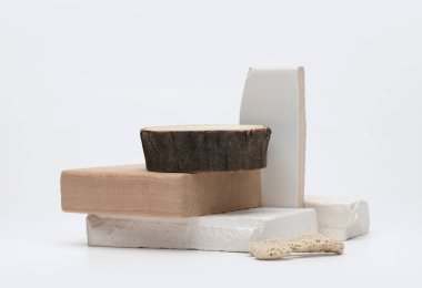 Gri ışıklı fotokopi arkaplanının üzerine beyaz taşlar ve ahşap platform podyumu istifleyin. En az boş ürün sunum sahnesi.