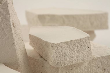 Gri ışıklı fotokopi arkaplanındaki beyaz taşlar platformu. En az boş ürün sunum sahnesi.