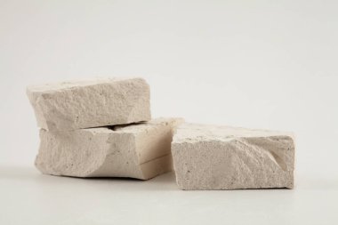 Gri ışıklı fotokopi arkaplanındaki beyaz taşlar platformunu istifleyin. En az boş ürün sunum sahnesi.