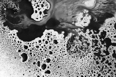 Mürekkep suluboya akışı damla damla damlatır. Soyut doku siyah beyaz renk arkaplanı.