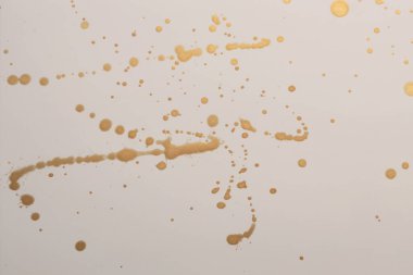 Altın yaldızlı mürekkep, bej kağıt dokusu üzerine suluboya damlası lekesi.