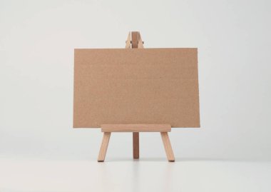 Küçük ahşap sehpanın üzerine boş kopya kâğıt tuval. Art Light bej arkaplan.