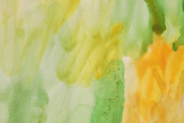 Islak kağıt desenli arka planda mürekkep rengi el boyası lekesi çizilmiş. Yeşil, Turuncu, Sarı.