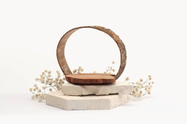 Taşlar, ahşap platform podyumu, bej ışıklı arka planda çiçek dalı. En az boş ürün sunum sahnesi.