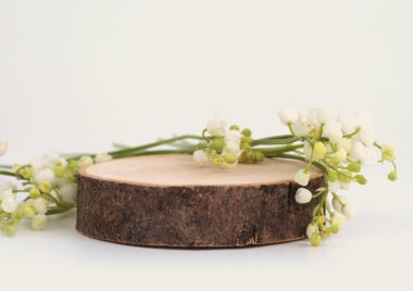 Tahta kütük platform podyumu ve vadi arka planındaki zambak. En az boş ürün sunum sahnesi.