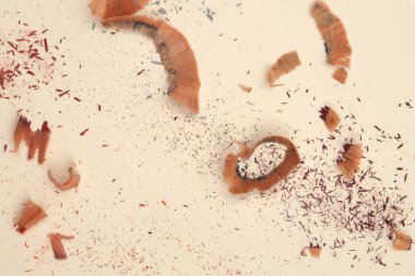 Bej kağıt arkaplanda kalem keskinleştirme talaşı.