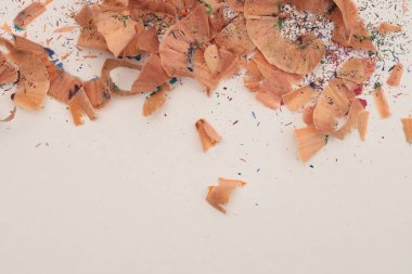 Bej kağıt arkaplanda kalem keskinleştirme talaşı.