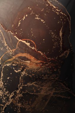 Parlak dumanlı bronz parıltılı tahıl desenli benekli leke. Siyah arkaplanda soyut ışıklandırma lekesi.