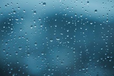 Soft focus  through glass with wet water drops. Abstract blue natural  blur background.