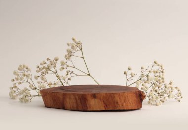 Tahta ağaç çember kütüğü, platform podyum plakası, bej rengi gri arka planda çiçek dalı. En az boş ürün sunum sahnesi.