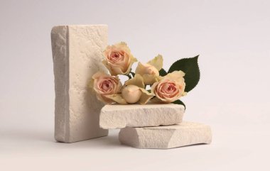 Stones platformu podyumu, gri arka planda bej kremalı gül çiçeği buketi. Ürün sunum sahnesi için en az boş temel.