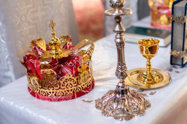 Altın taçlar ve bir bardak şampanya.