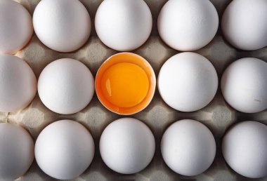 Tavuk yumurtası ve tavuk yumurtası beyaz bir kabın içinde.