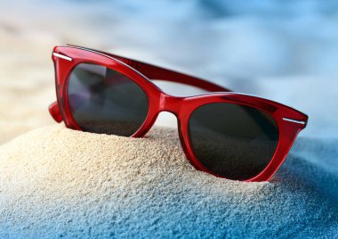 Sahilde kırmızı kumlu kırmızı güneş gözlüğü.