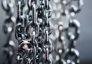 Metal bir zincirin arka planında metal zincirler olan çelik zincirler.