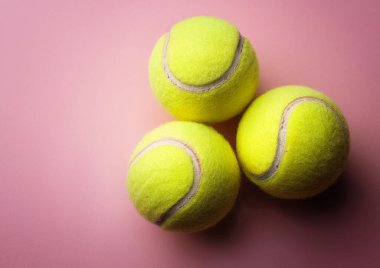  Tenis raketleri ve pembe arka planda tenis topları, 3 boyutlu illüstrasyon
