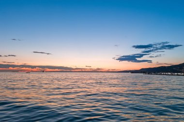 Adriyatik Denizi kıyısında, Trieste, İtalya 'da gün batımında Alp Dağları açık yaz akşamlarında arka planda