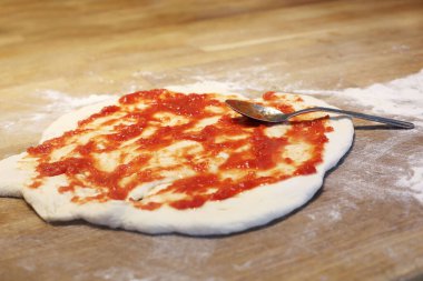 Ev yapımı pizza hamuru, mozarella peyniri ve domates sosu.