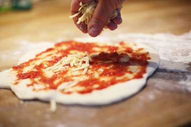 Ev yapımı pizza hamuru, mozarella peyniri ve domates sosu.