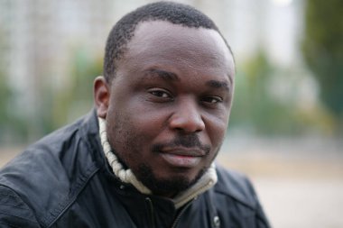 Nijeryalı Afrikalı Amerikalı adam kameraya bakıyor.
