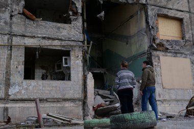 KYIV, UKRAINE, APRIL 15, 2022: After bombing. Russian aggression. War in Ukraine. Men near dwelling house destroyed by russian shell on March 14, 2022. Terror and genocide of Ukrainian people