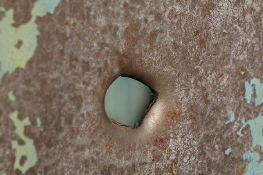 Hole in metal from a real missile explosion. After bombing. War in Ukraine, terror and genocide of Ukrainian people. Russian missile destroyed houses and metallic garages in residential area