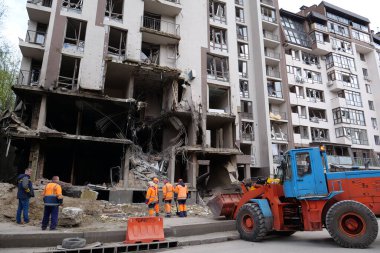 KYIV, UKRAINE, APRIL 29, 2022: Workers clear rubble after bombing. Dwelling house damaged by russian missile on April 28, 2022. War in Ukraine. Terror and genocide of Ukrainian people