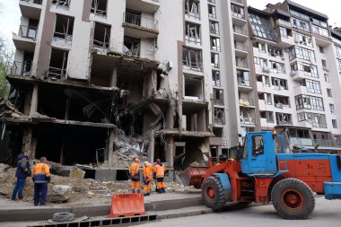 KYIV, UKRAINE, APRIL 29, 2022: Workers clear rubble after bombing. Dwelling house damaged by russian missile on April 28, 2022. War in Ukraine. Terror and genocide of Ukrainian people