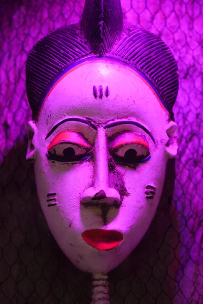 African mask under violet light