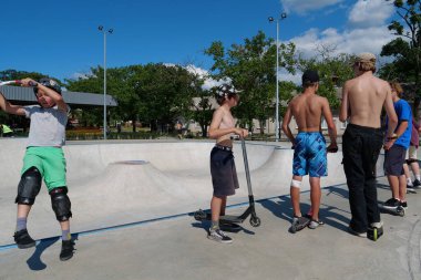 KYIV, UKRAINE, 26 Temmuz 2022: Kyiv şehrindeki çok amaçlı sergi kompleksi Ukrayna 'nın merkezindeki yeni açık hava spor sahasında erkekler scooter sürüyor