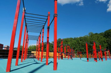 Şehirdeki açık hava spor sahasında yatay çubukları ve diğer yeni egzersiz ekipmanlarıyla spor sahası. Açık havada fiziksel egzersiz için spor sahası