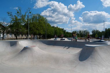 KYIV, UKRAINE, 26 Temmuz 2022: Kyiv şehrindeki çok amaçlı sergi kompleksi Ukrayna 'nın merkezindeki yeni açık hava spor sahasında erkekler scooter sürüyor