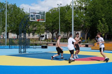 KYIV, UKRAINE, JULY 26, 2022: Young lads plays streetball at new open air sport zone at expocenter of Ukraine