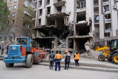 KYIV, UKRAINE, APRIL 29, 2022: Workers clear rubble after bombing. Dwelling house damaged by russian missile on April 28, 2022. War in Ukraine. Terror and genocide of Ukrainian people
